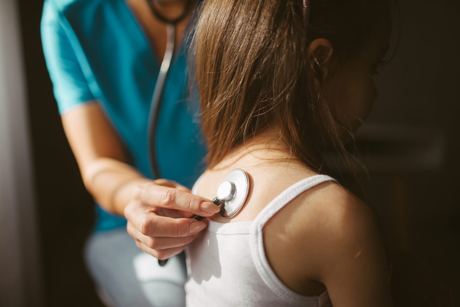 A physician warmly listening to a patient during a check-up
